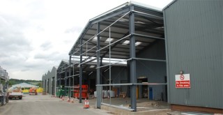 Steel building in construction showing the portal frame and cladding